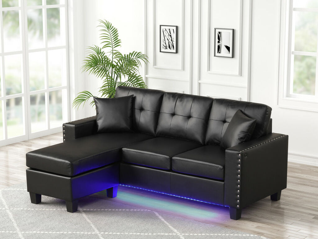 89343 Sorenza black faux leather reversible chaise 74" wide sectional sofa with under sofa LED lighting USB charging nail head trim